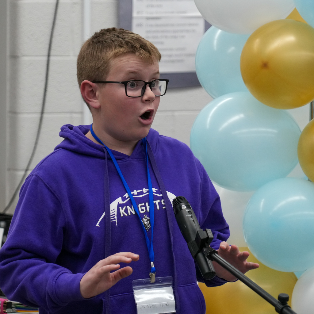 Students telling stories at a microphone.