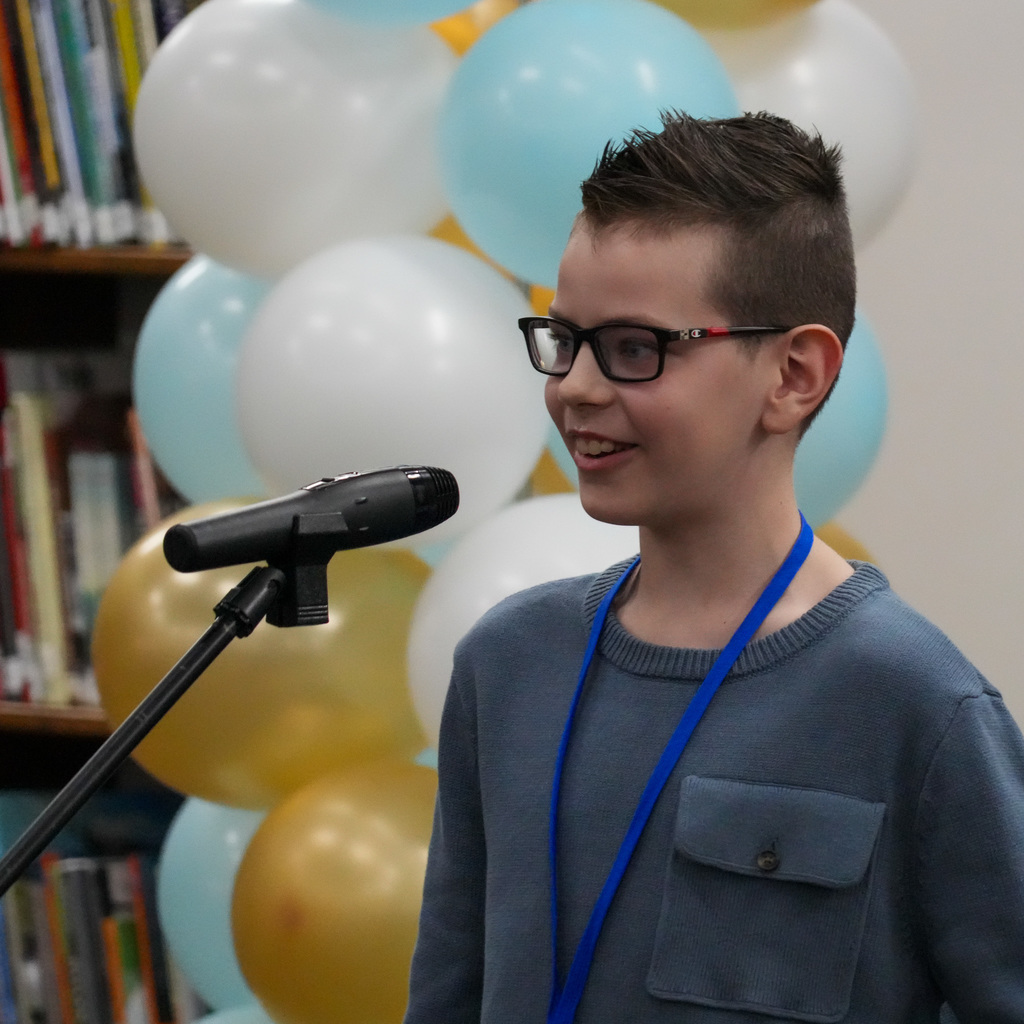 Students telling stories at a microphone.