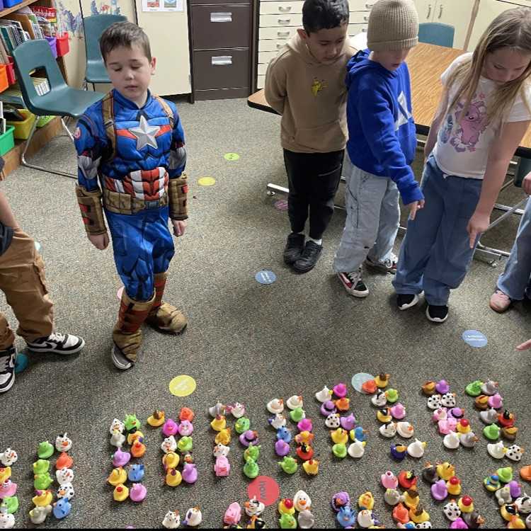 Second grade students counting various colors and types of rubber ducks in groups. 