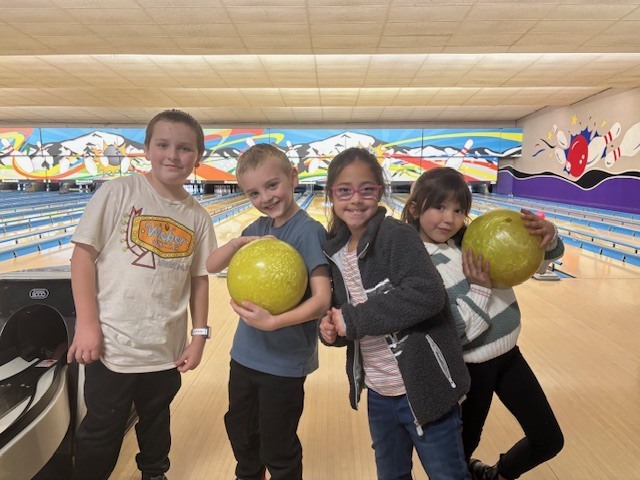 students smiling with bowling balls