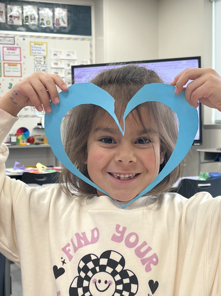 student with a paper heart around her face