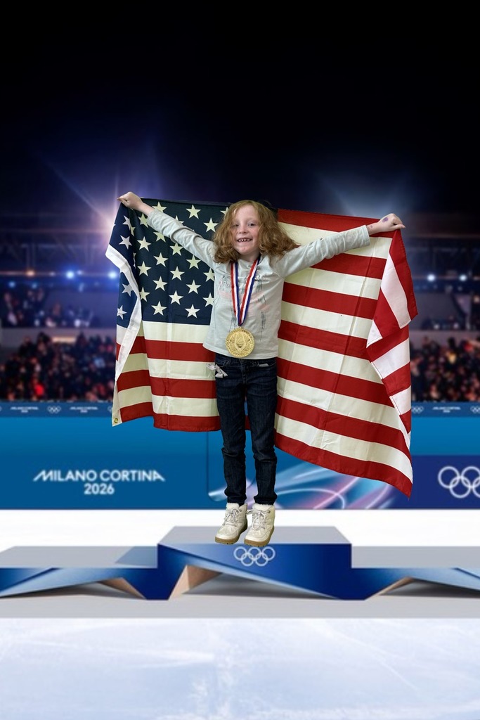 first grade student standing on an olympic podium wearing a gold medal and holding the USA Flag