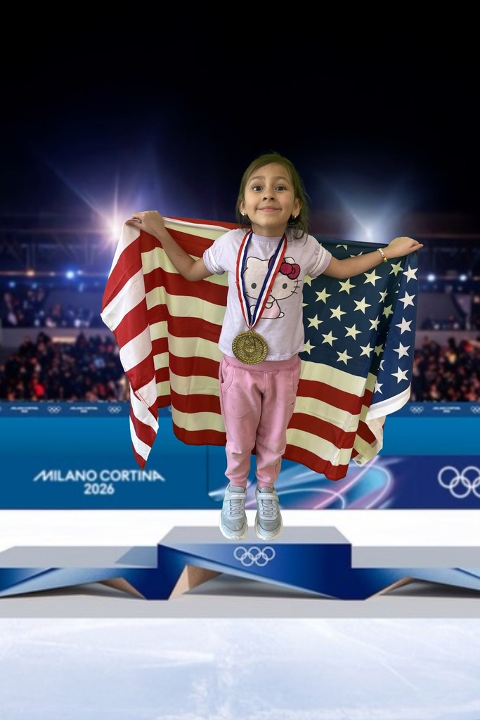 first grade student standing on an olympic podium wearing a gold medal and holding the USA Flag