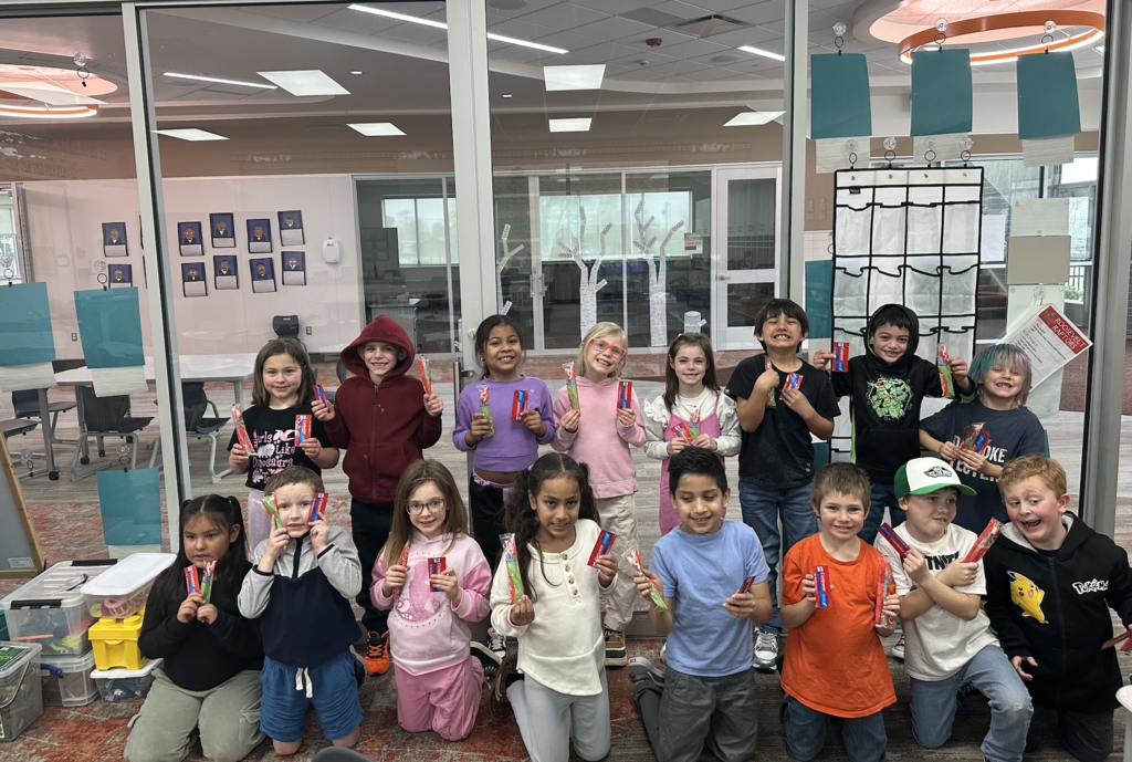 first grade class standing all together holding their new toothbrushes and toothpaste 