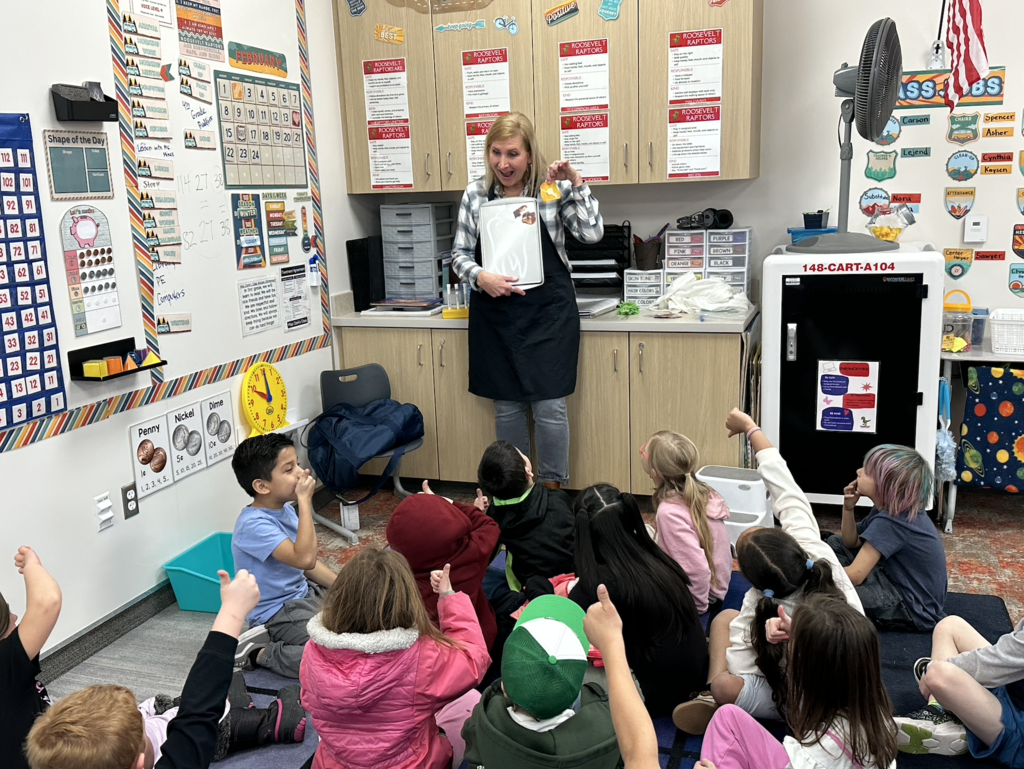 students collectively showing thumbs up or thumbs down for healthy foods that the nurse is presenting