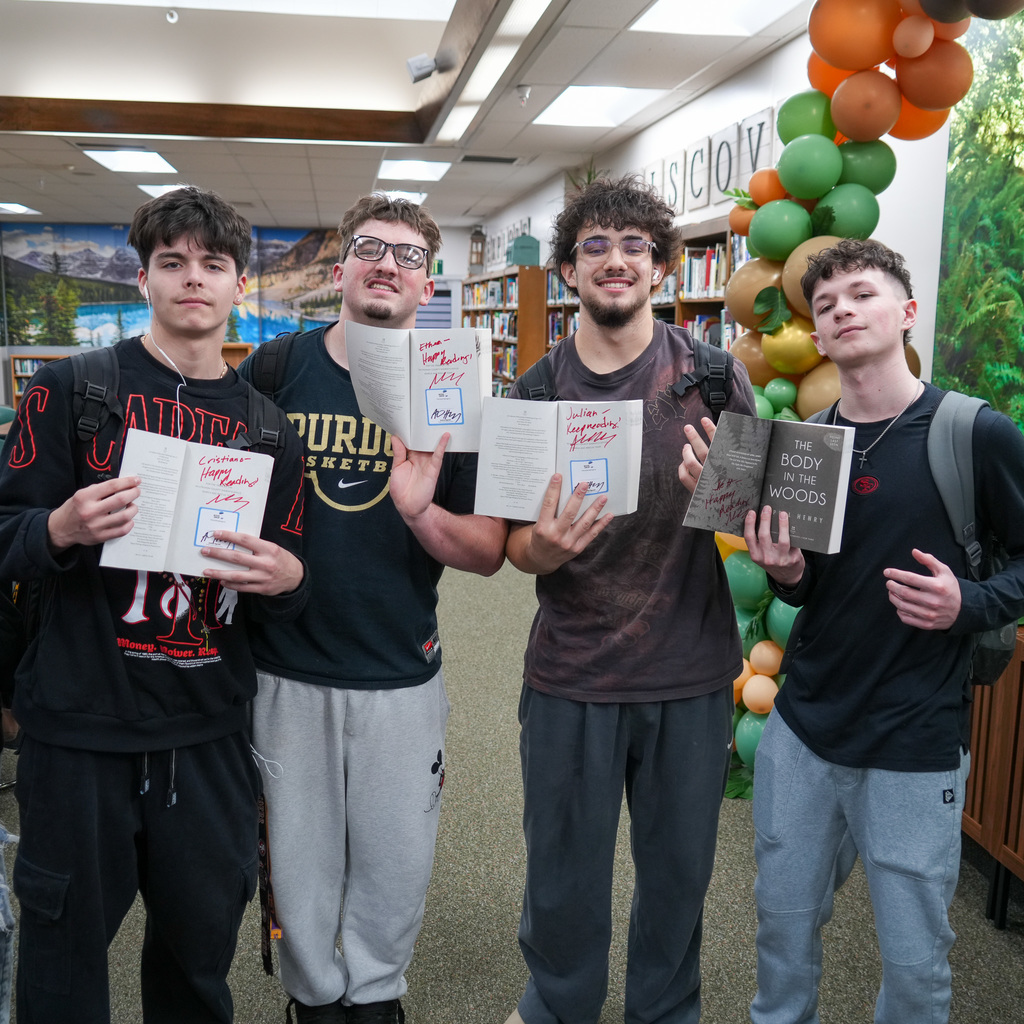 Students listening and receiving signed book from author
