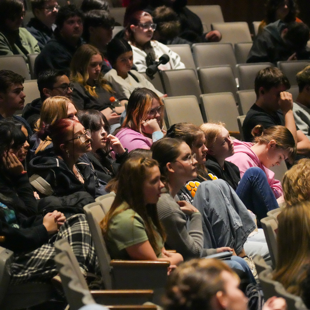 Students listening and receiving signed book from author
