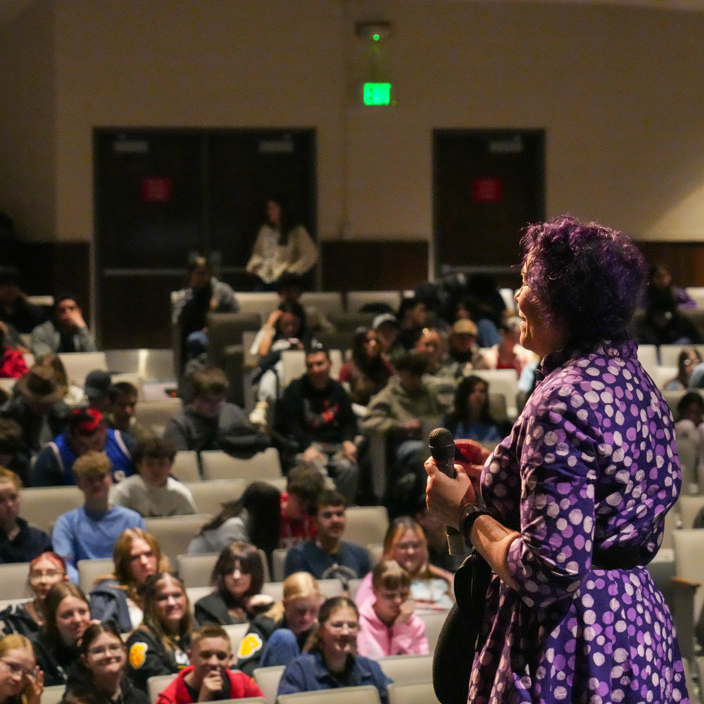 Students listening and receiving signed book from author