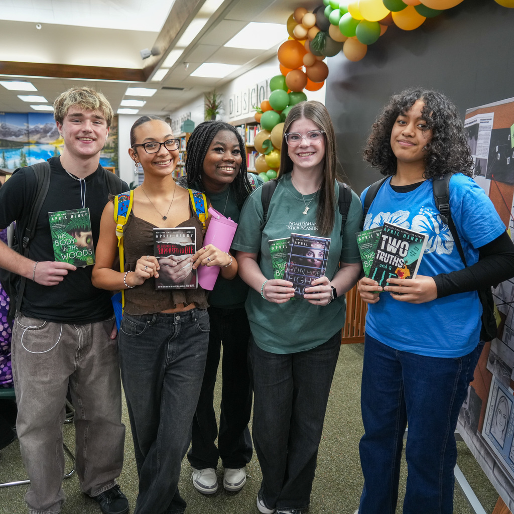 Students listening and receiving signed book from author