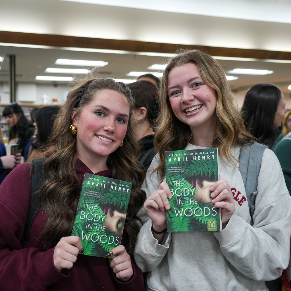 Students listening and receiving signed book from author