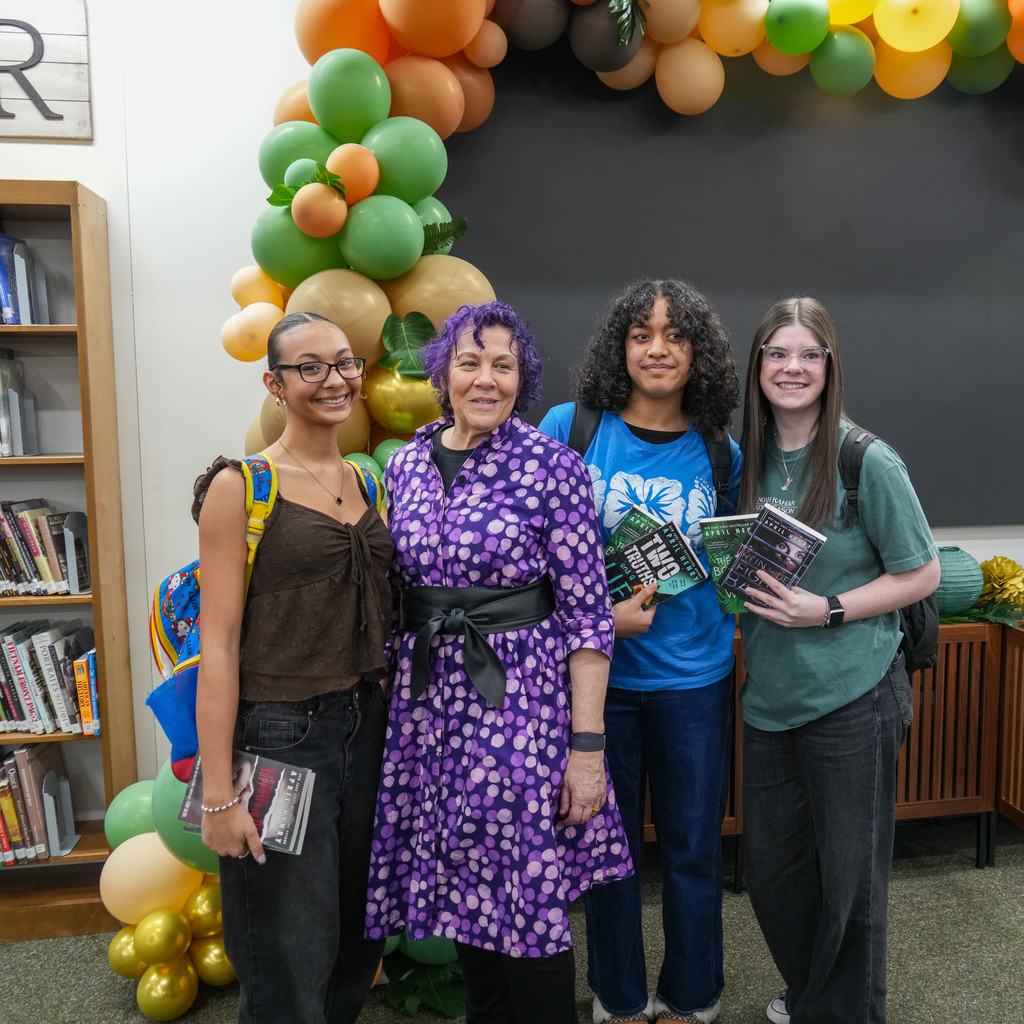 Students listening and receiving signed book from author