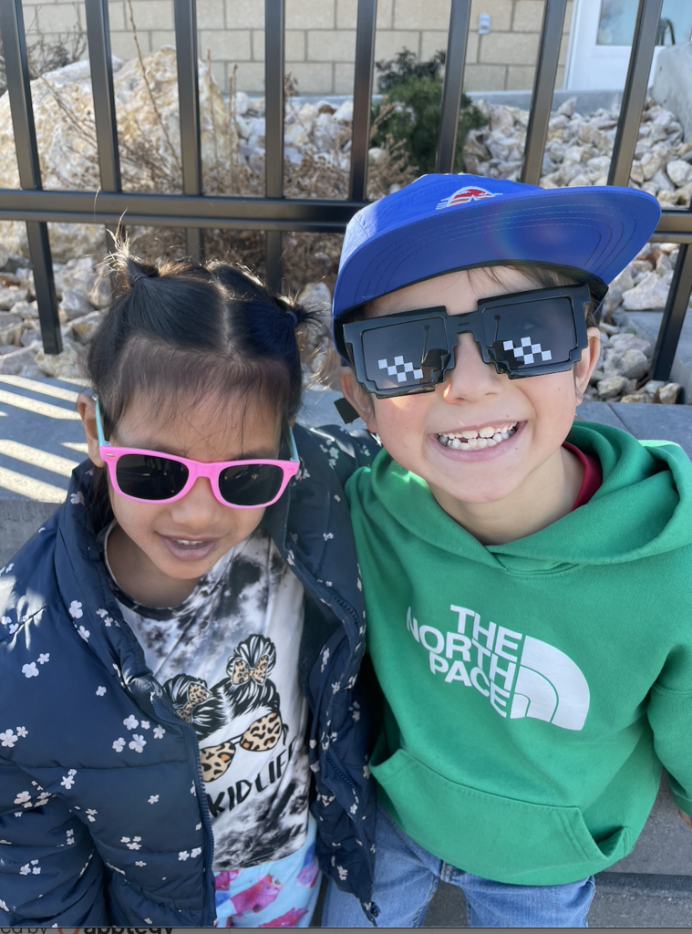 two students smiling and wearing sun glasses