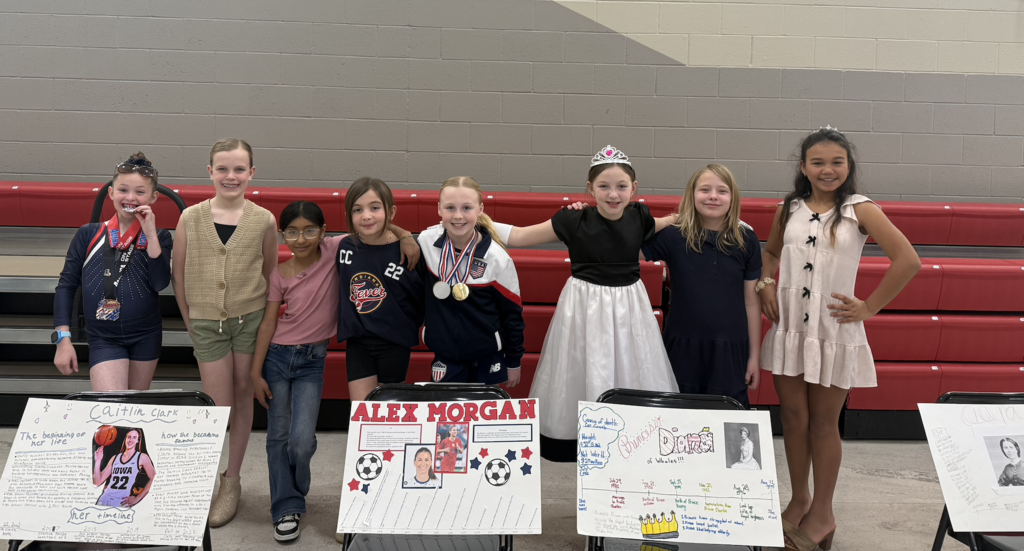 the 4th grade girls posing in the auditorium for the wax museum presentation 