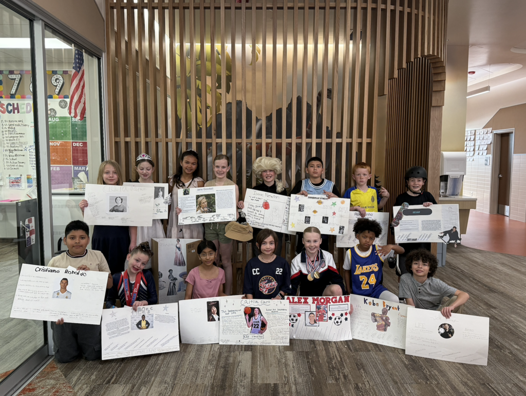 Students dressed up as a famous leaders holding the posters that they created for the wax muesum