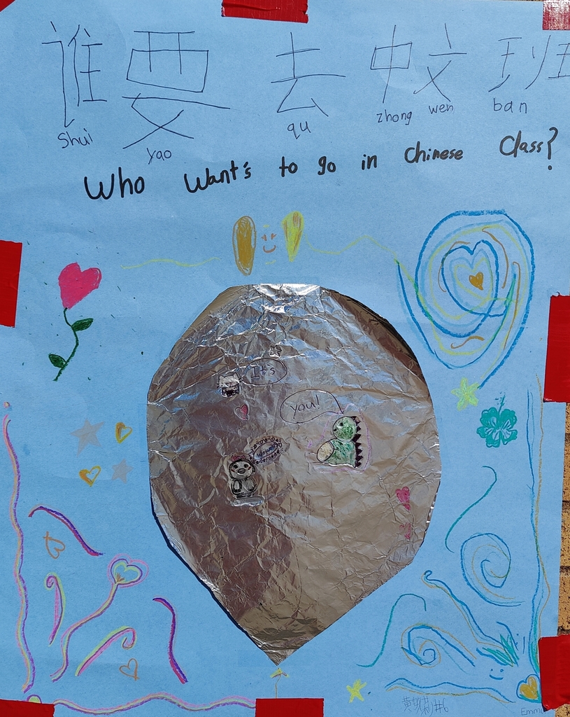 This is a rectangular, hand-drawn poster on light blue paper. With the words Chinese Characters: 谁 (Shéi) 要 (yào) 去 (qù) 中 (zhōng) 文 (wén) 班 (bān) English Translation: Who Want's to go in Chinese Class? This poster includes A large, crumpled piece of silver aluminum foil is taped to the center of the poster. A small yellow hand-drawn thought bubble above the foil says, "It’s You!". Cutouts of a smiling panda and a happy green dinosaur are glued to the foil. Doodles and Artwork: The entire poster background is covered in small, multi-colored crayon and colored pencil drawings: Left side: A pink flower in a heart shape and several individual hearts. Right side: A large blue spiral pattern with small green clovers and more hearts. Bottom edge: A wave of diverse, multi-colored squiggly lines with hearts.