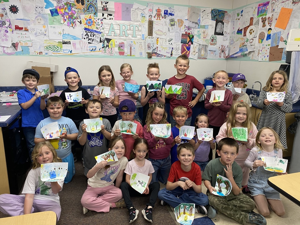 first grade students holding art work