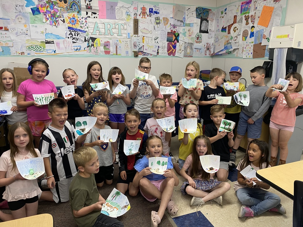 first grade students holding art work