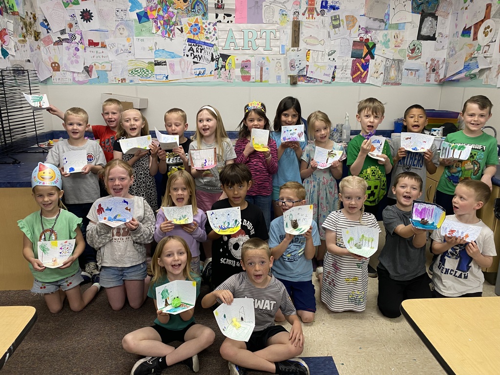 first grade students holding art work