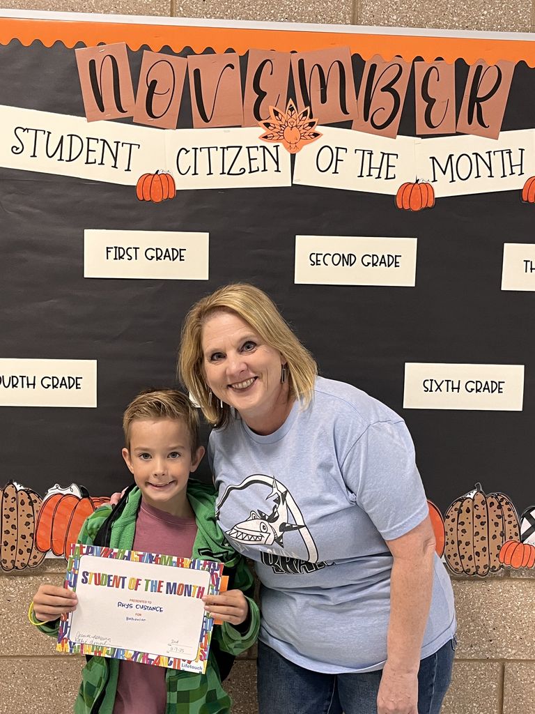 Photograph of student and citizen of the month award with teacher and students.