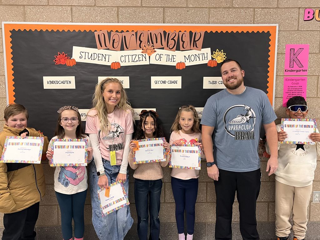 Photograph of student and citizen of the month award with teacher and students.