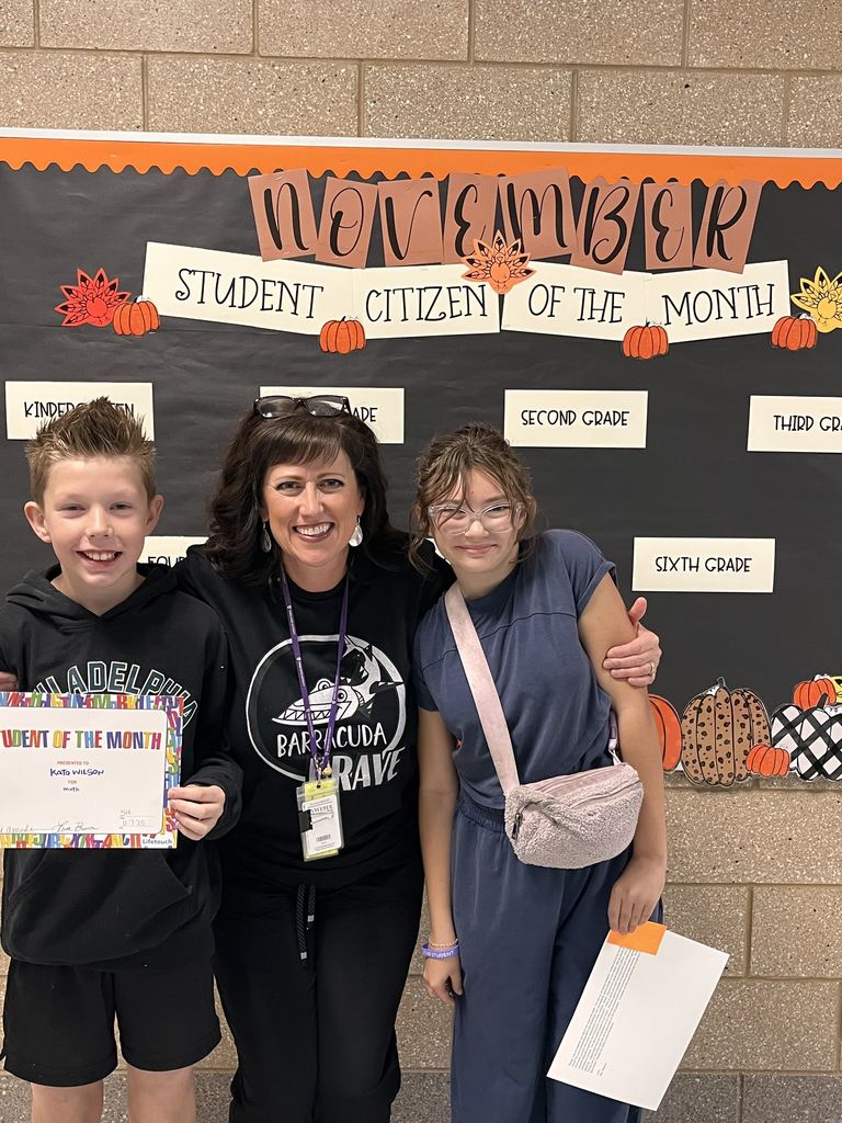 Photograph of student and citizen of the month award with teacher and students.
