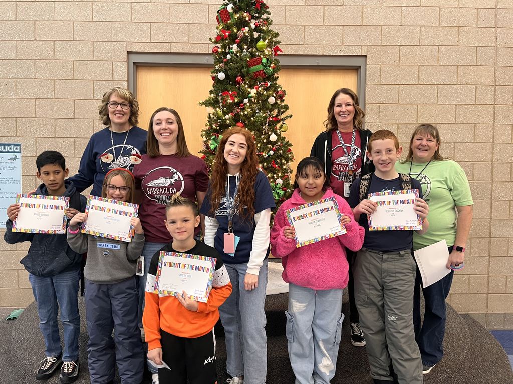 Photograph of student and citizen of the month award with teacher and students.