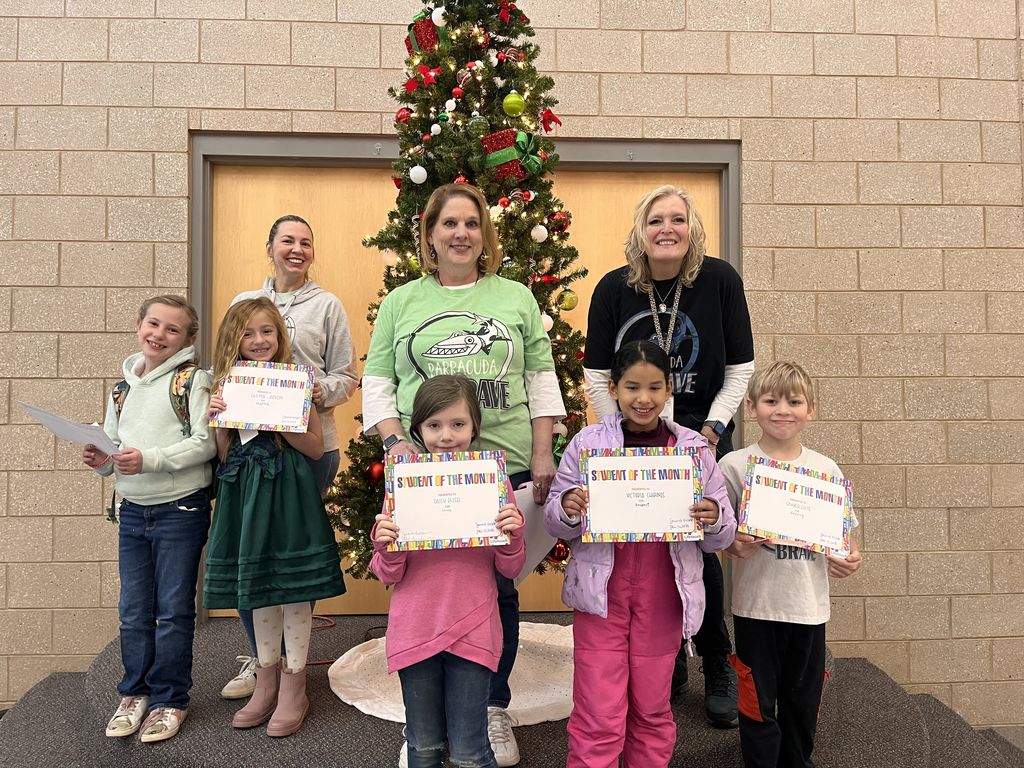 Photograph of student and citizen of the month award with teacher and students.