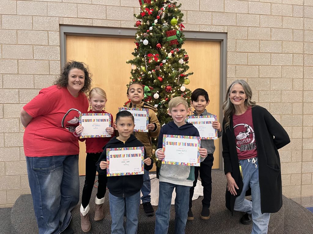 Photograph of student and citizen of the month award with teacher and students.