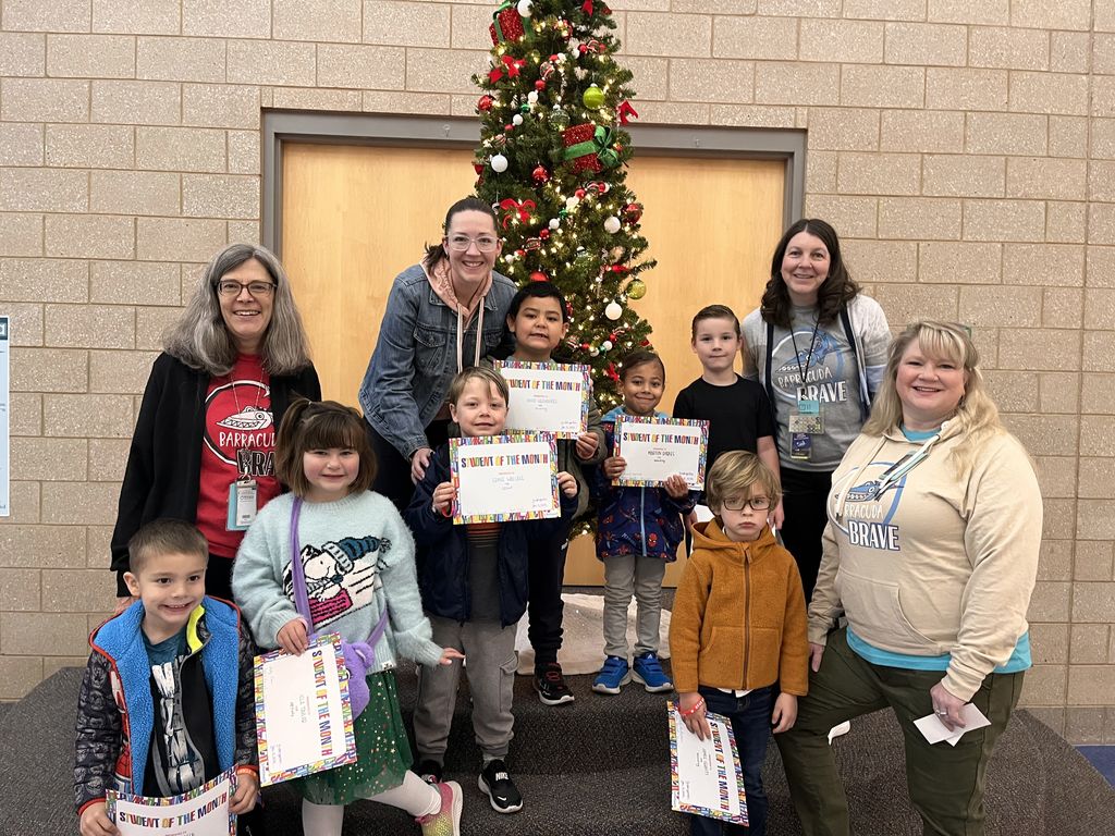 Photograph of student and citizen of the month award with teacher and students.