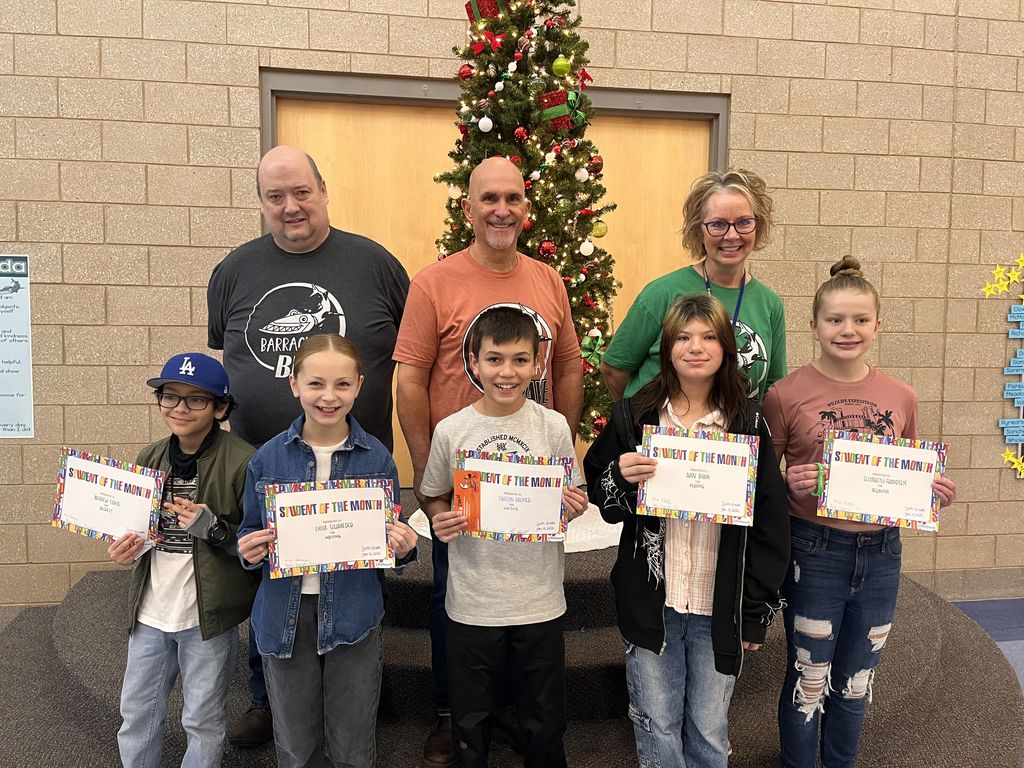 Photograph of student and citizen of the month award with teacher and students.