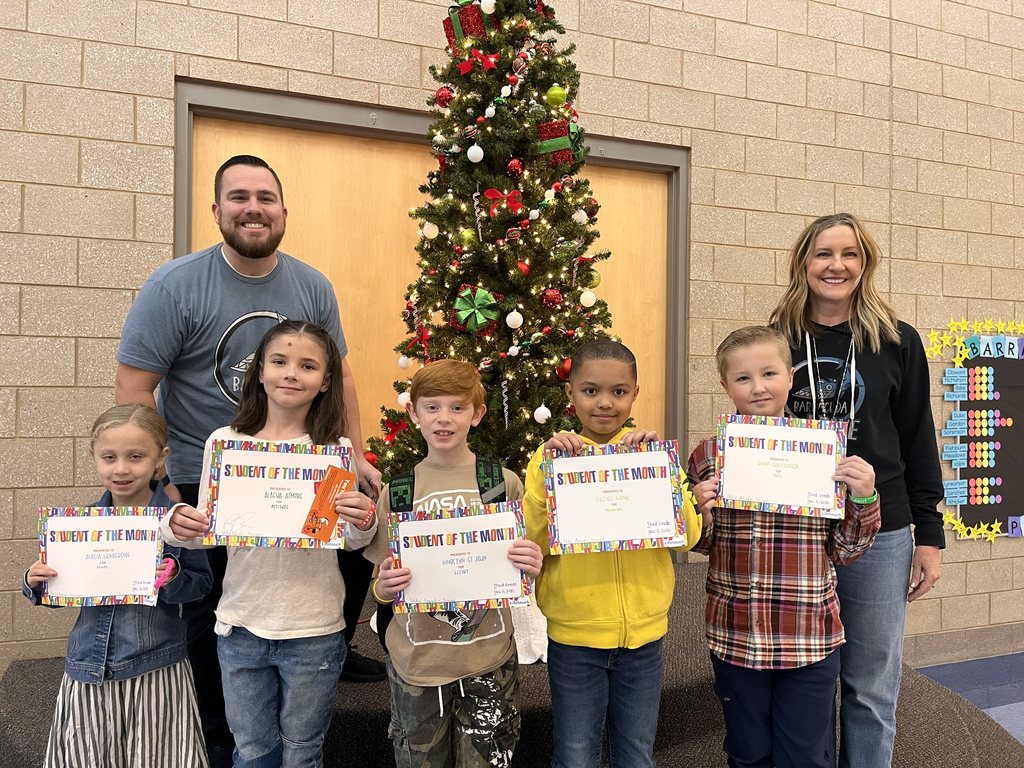 Photograph of student and citizen of the month award with teacher and students.