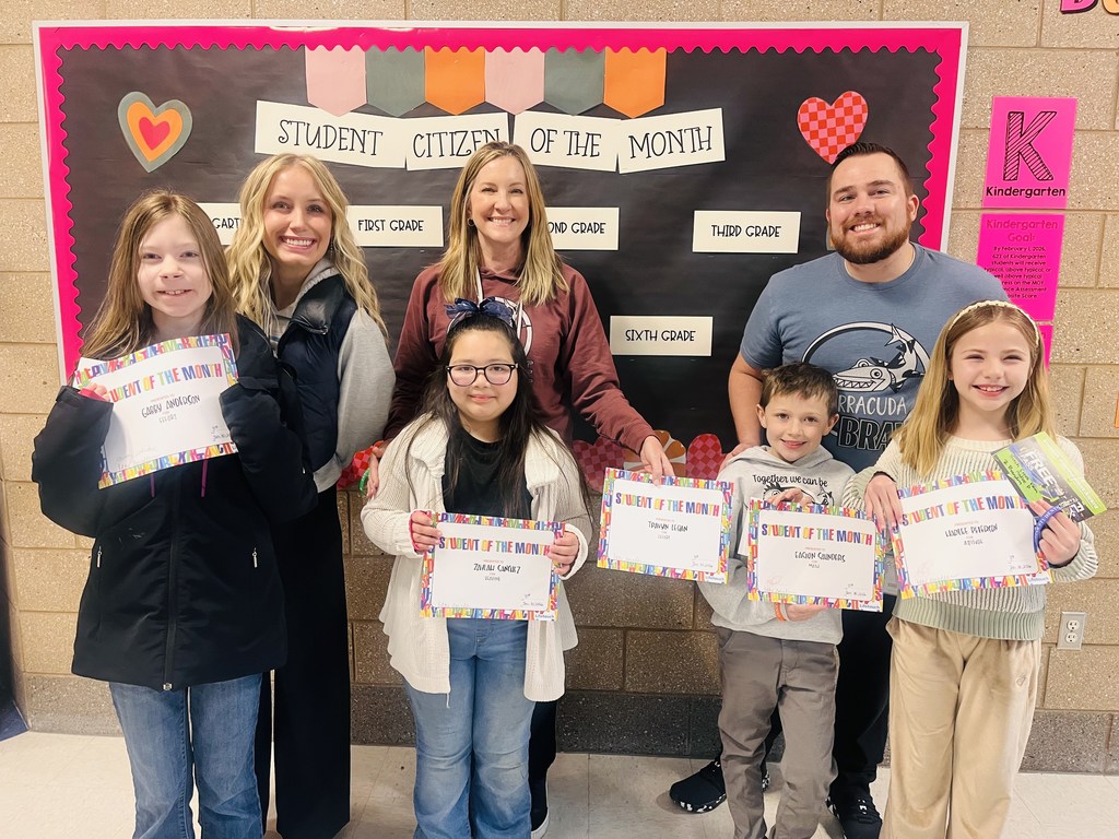 Photograph of student and citizen of the month award with teacher and students.
