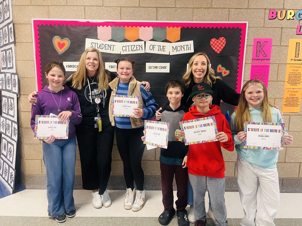 Photograph of student and citizen of the month award with teacher and students.