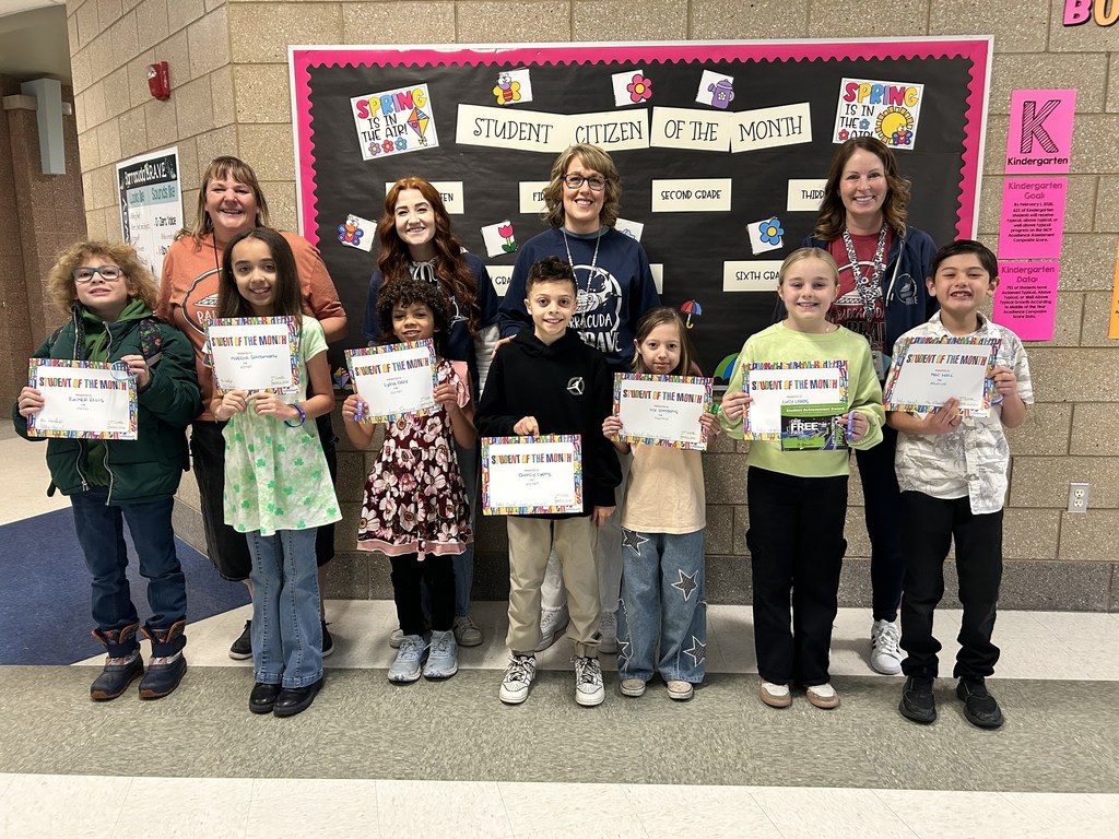 Photograph of student and citizen of the month award with teacher and students.