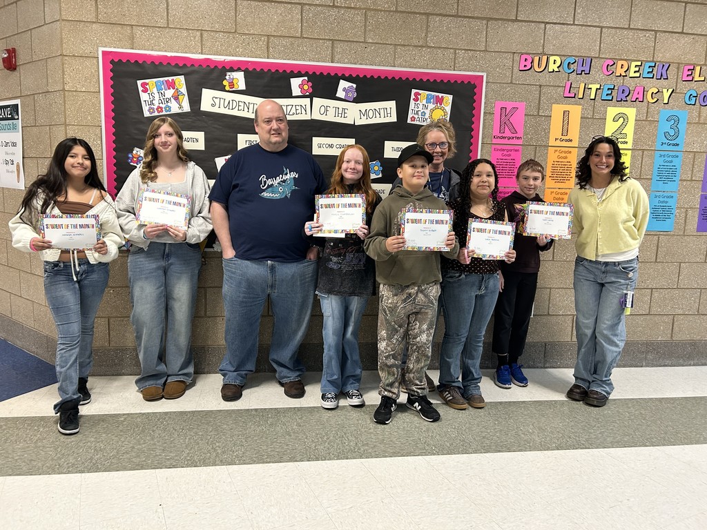 Photograph of student and citizen of the month award with teacher and students.