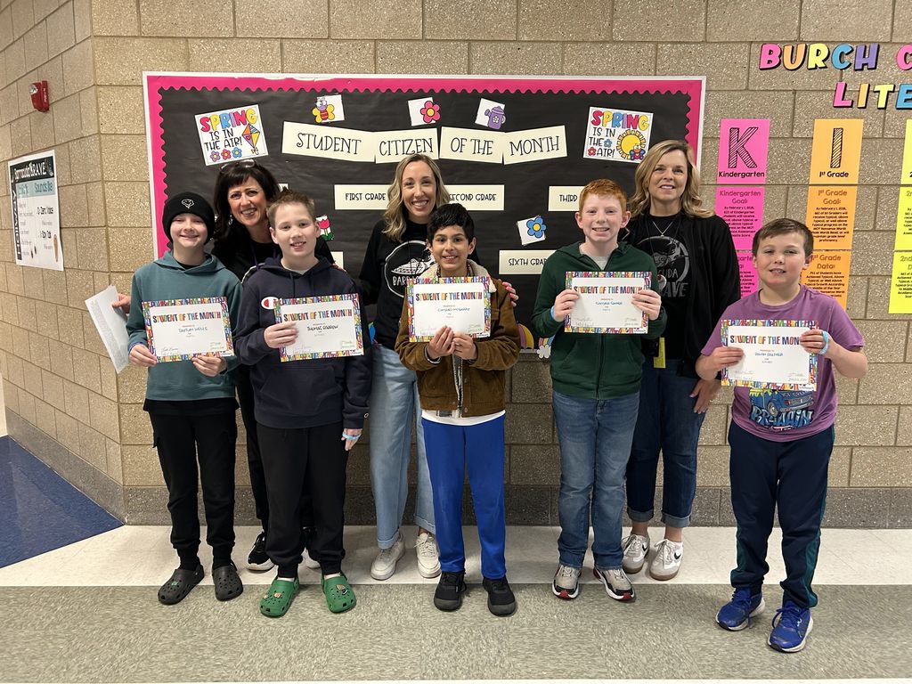 Photograph of student and citizen of the month award with teacher and students.