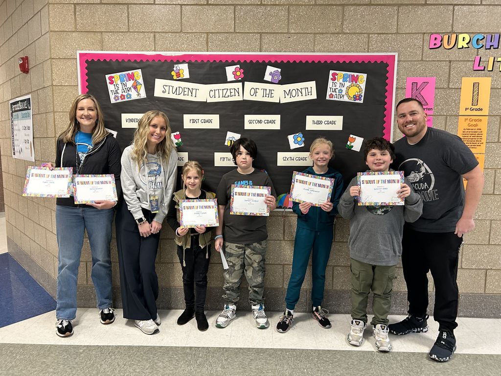 Photograph of student and citizen of the month award with teacher and students.