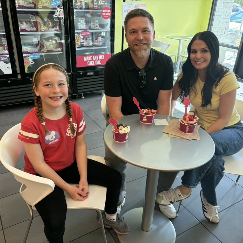 A girl and her parents eating Menchies 