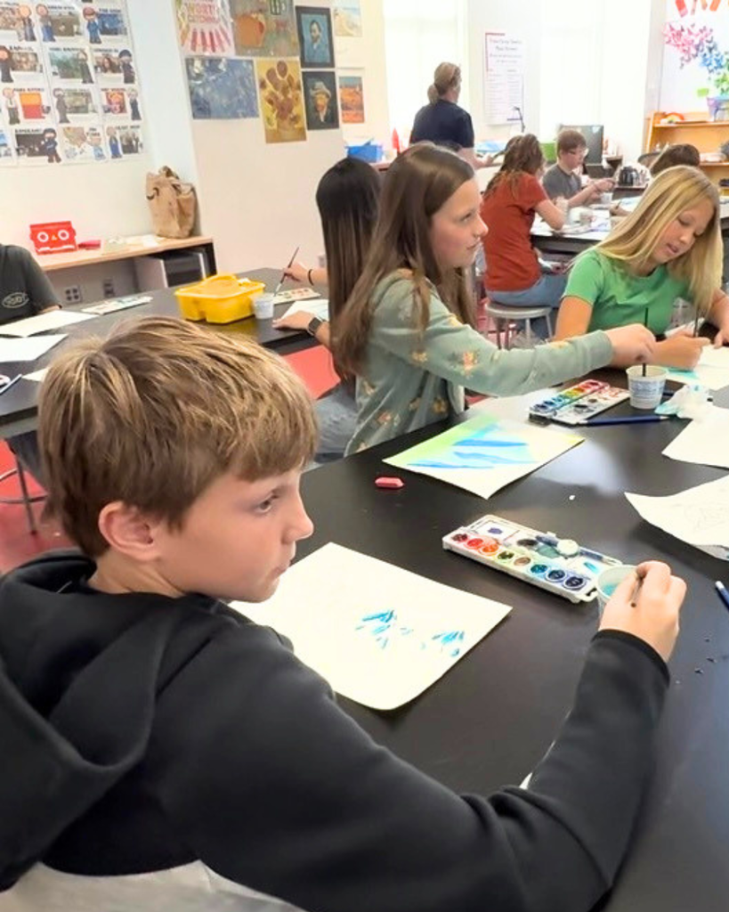Students smiling while painting with watercolors in art class, showcasing original artwork and the impact of the Beverly Taylor Sorenson Foundation grant.