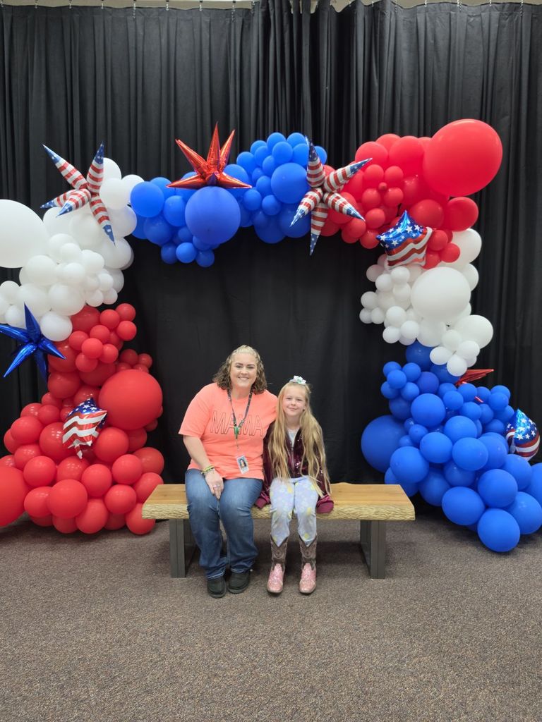 parent and student getting a picture next to balloon arch