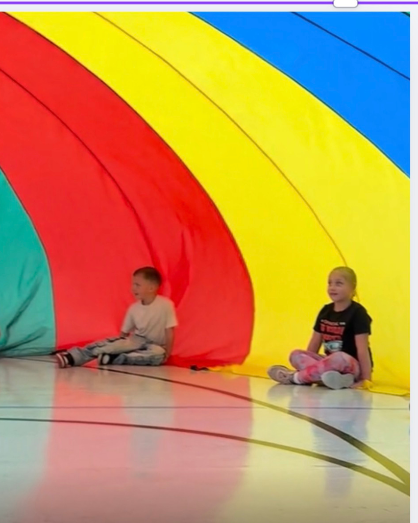Students  exploriing a parachute activty during a PE lesson. 