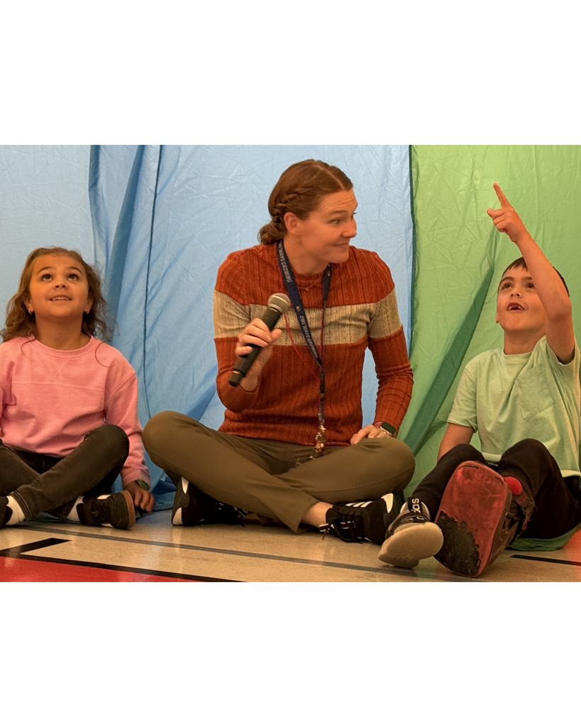 Students and teachers exploriing a parachute activty during a PE lesson. 