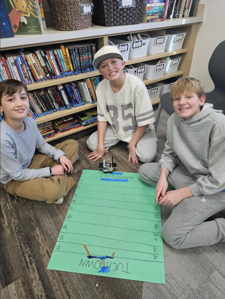 students smiling as they work on a football project 