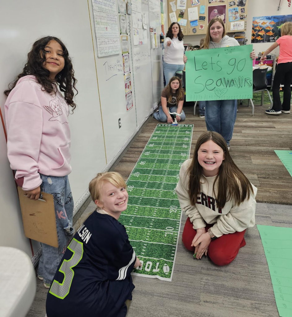 students smiling as they work on a football project 