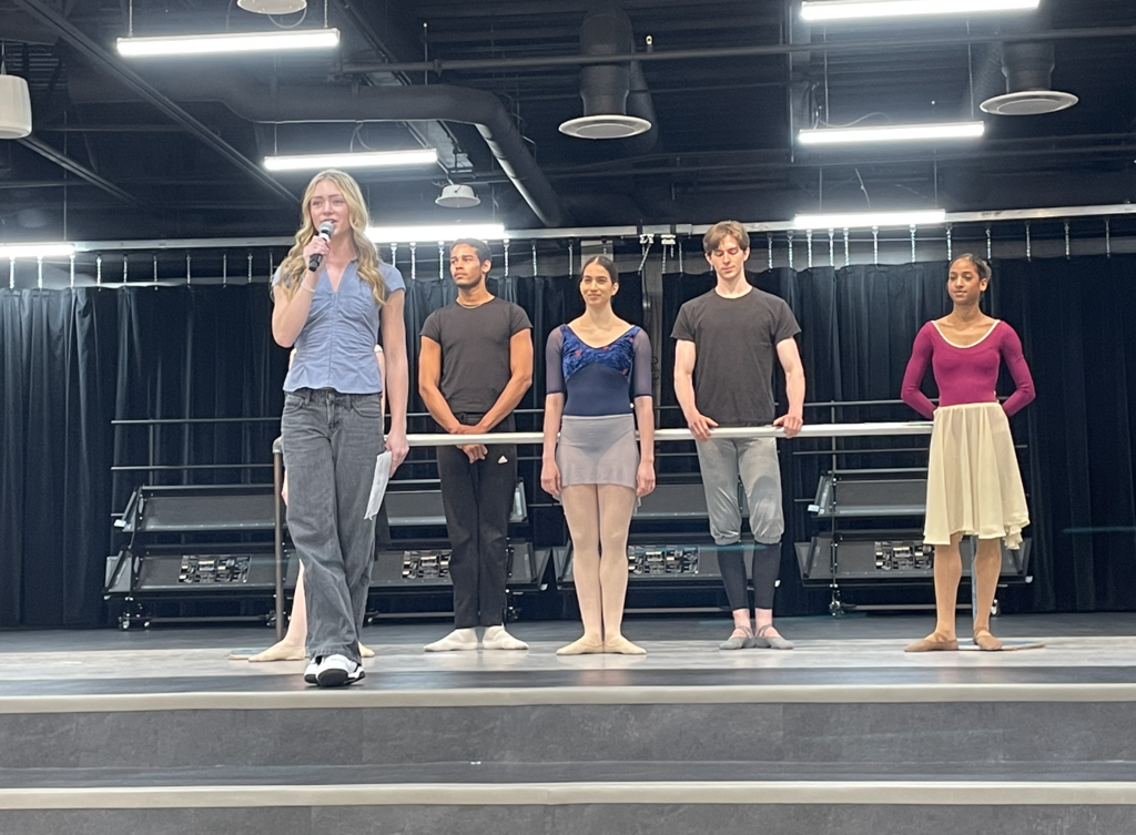 Ballet Dancers giving a description about ballet as the dancers stand at a bar 