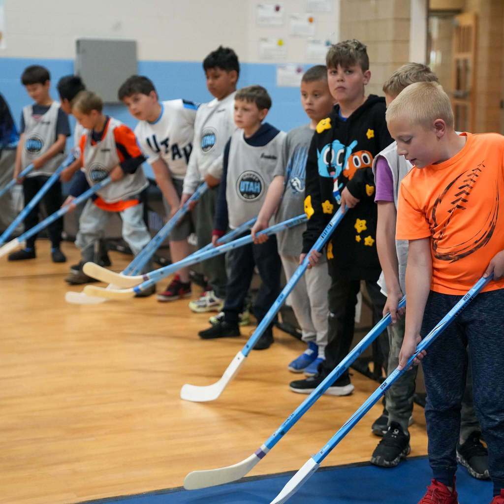 Students in the gym learning how to play street hockey from the Utah Mammoth.
