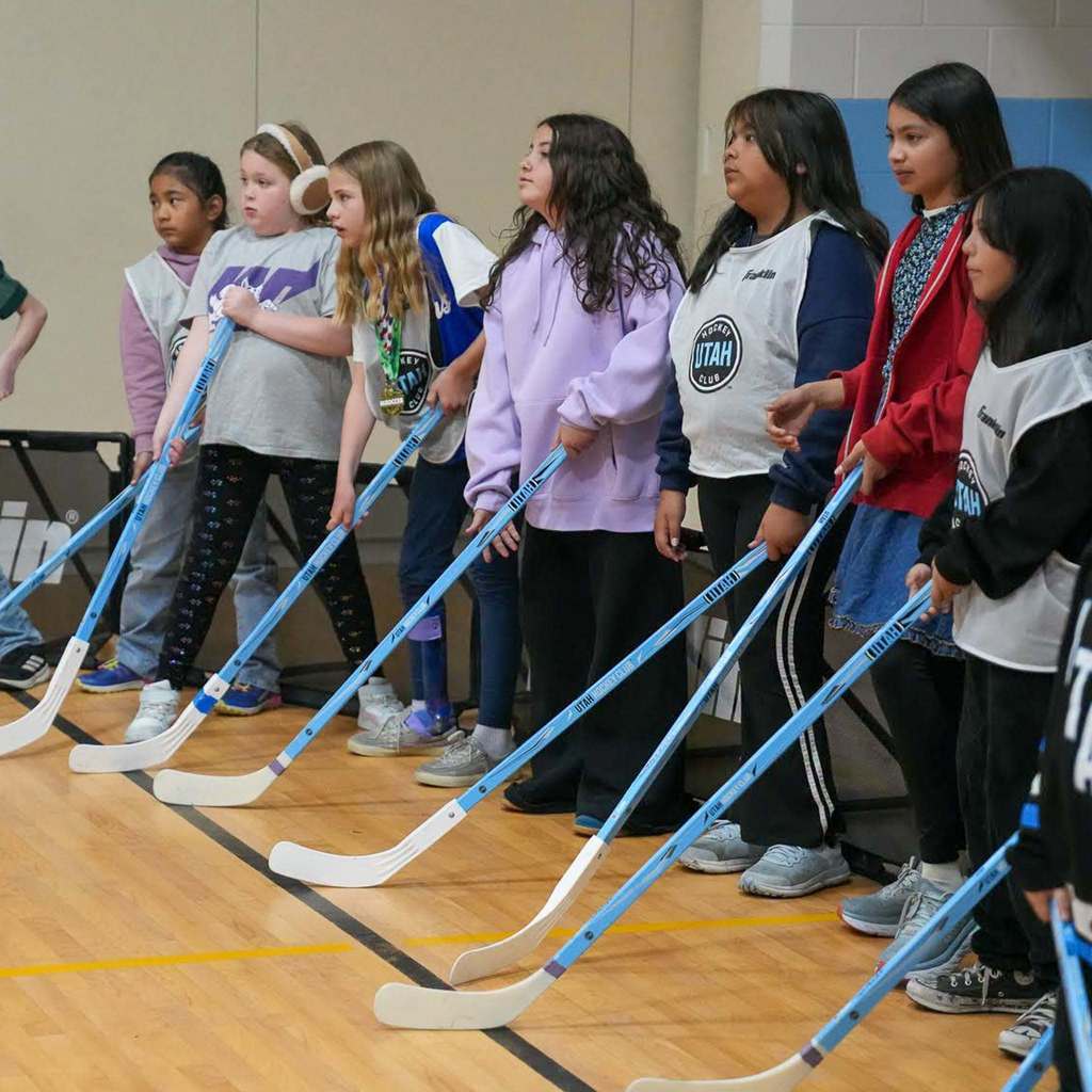 Students in the gym learning how to play street hockey from the Utah Mammoth.