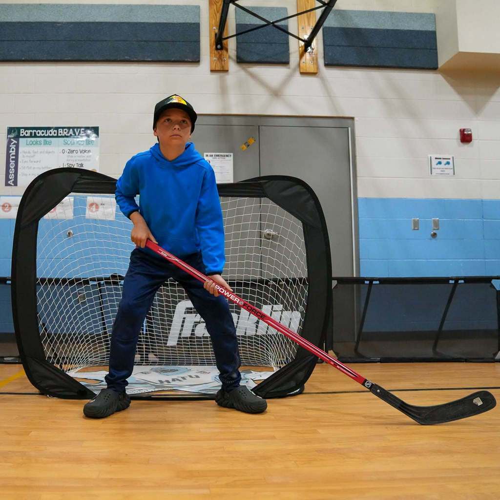 Students in the gym learning how to play street hockey from the Utah Mammoth.