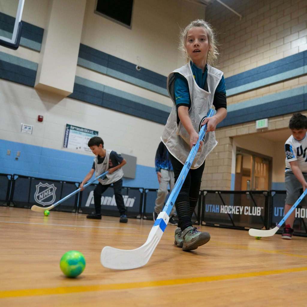 Students in the gym learning how to play street hockey from the Utah Mammoth.