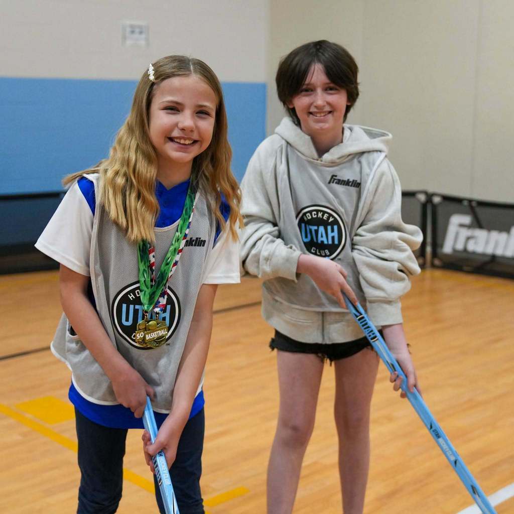 Students in the gym learning how to play street hockey from the Utah Mammoth.